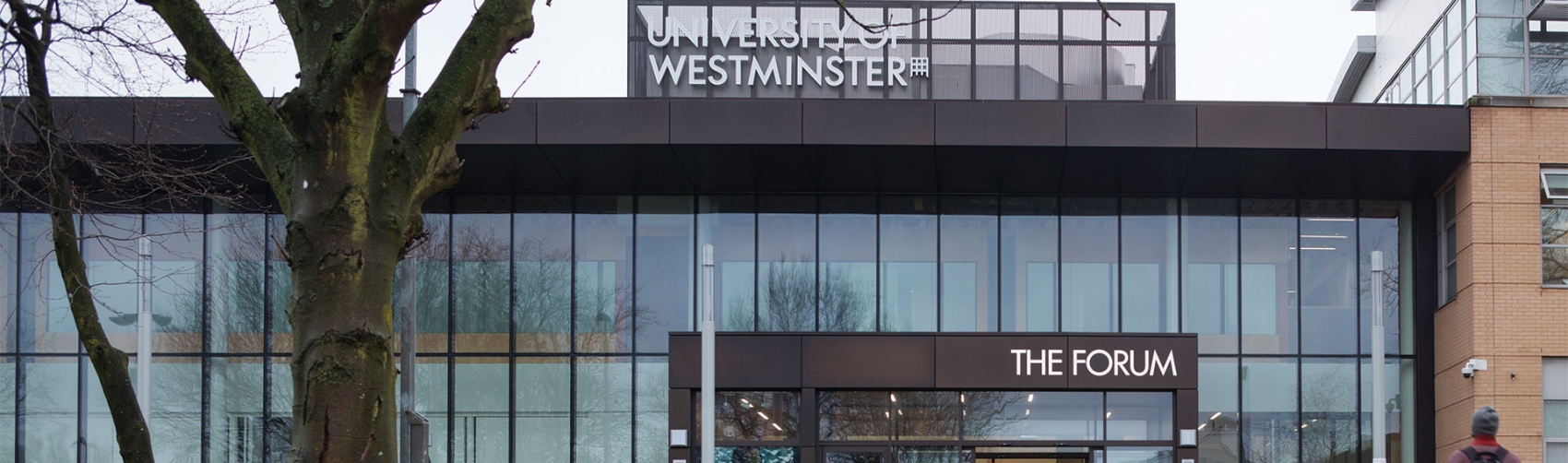 Glass fronted building with patch of grass in foreground.